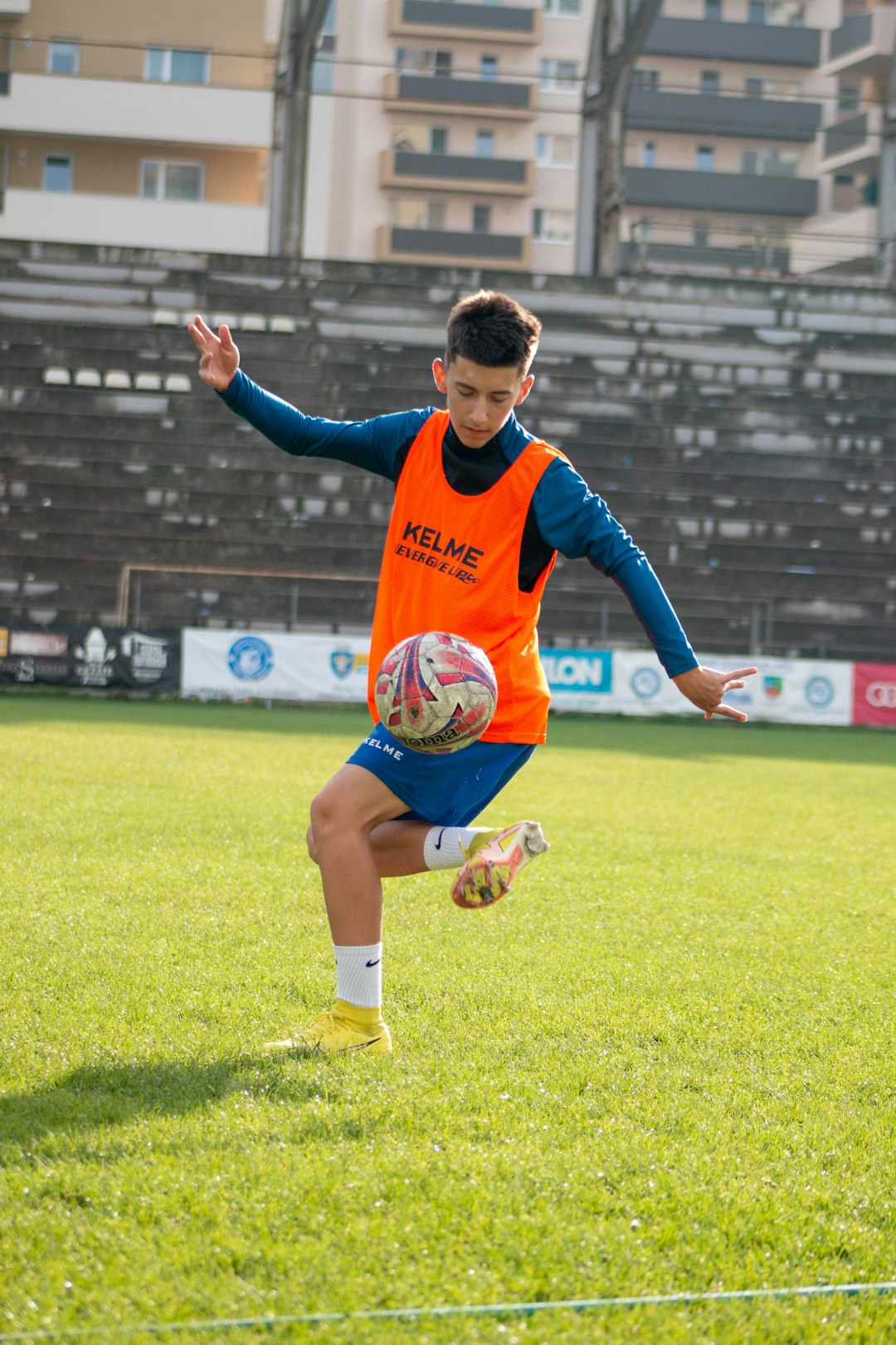 a boy in an orange shirt running on a field antonio di natale, udinese striker, italian football