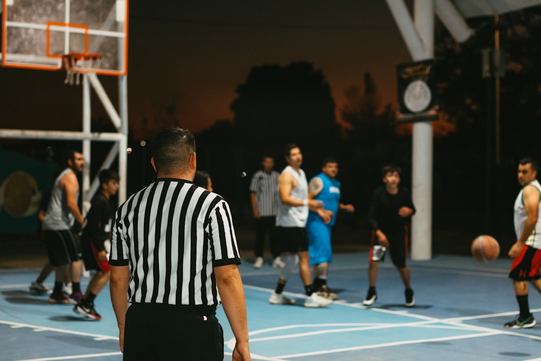 A group of men playing a game of basketball football referee, official timeout, american football game