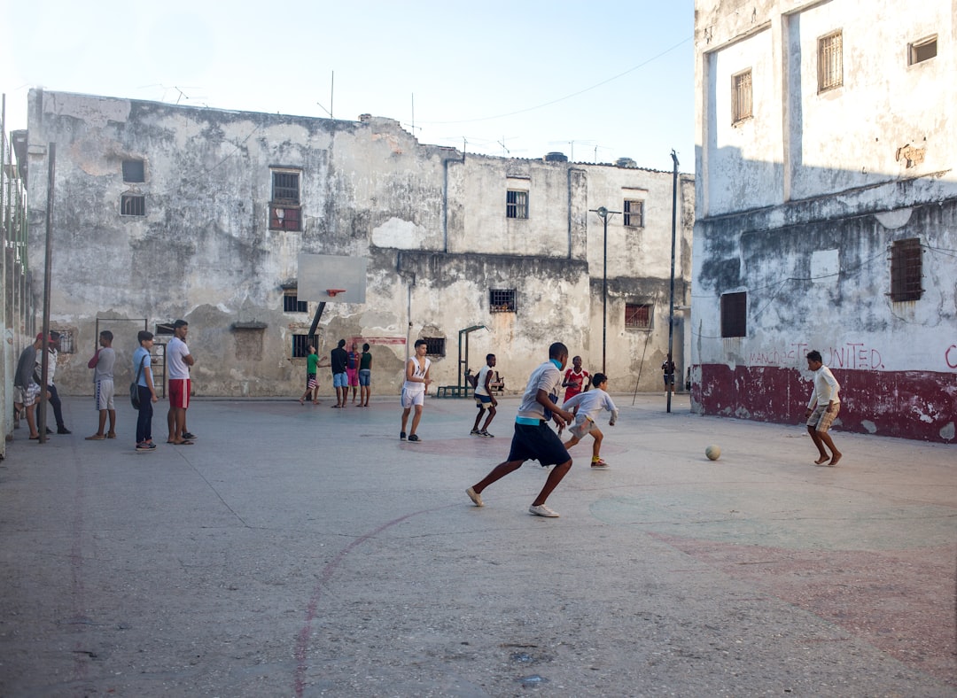 a group of people playing a game of basketball kids playing baseball, Dominican Republic, poor village