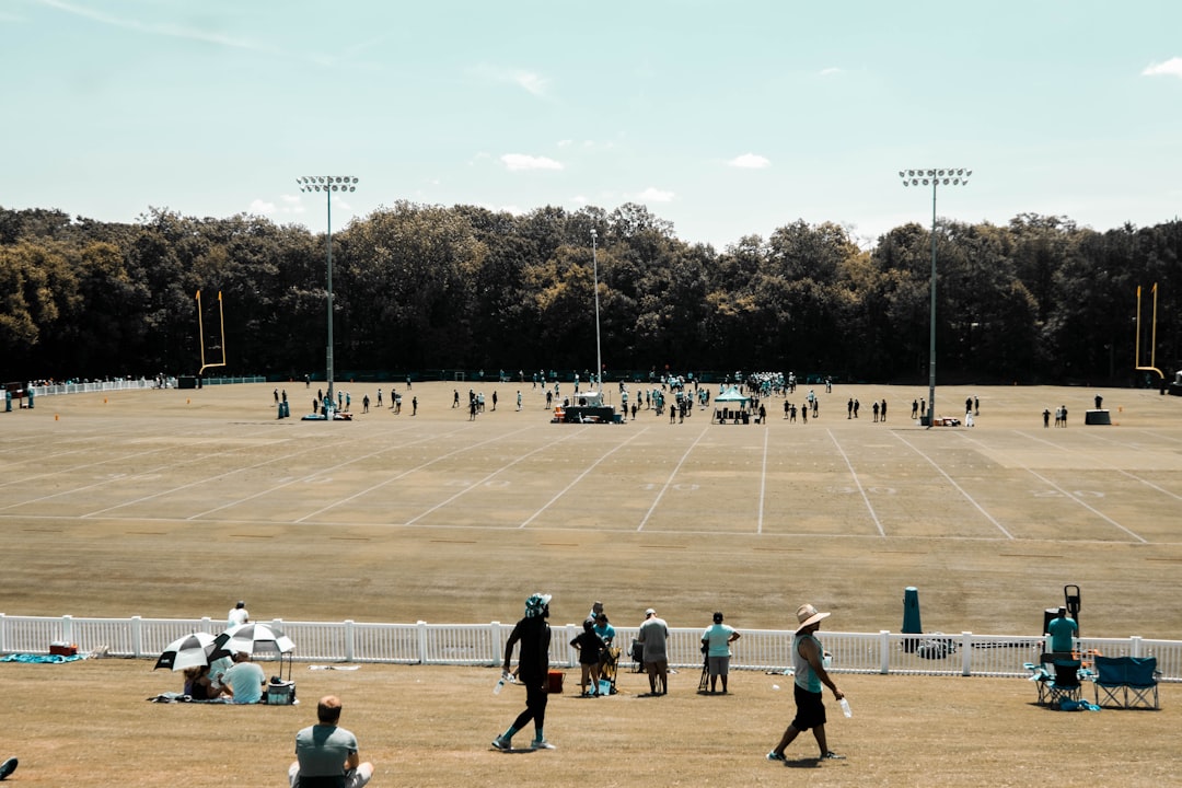 a group of people playing baseball football field lining,paint machine,sports lines
