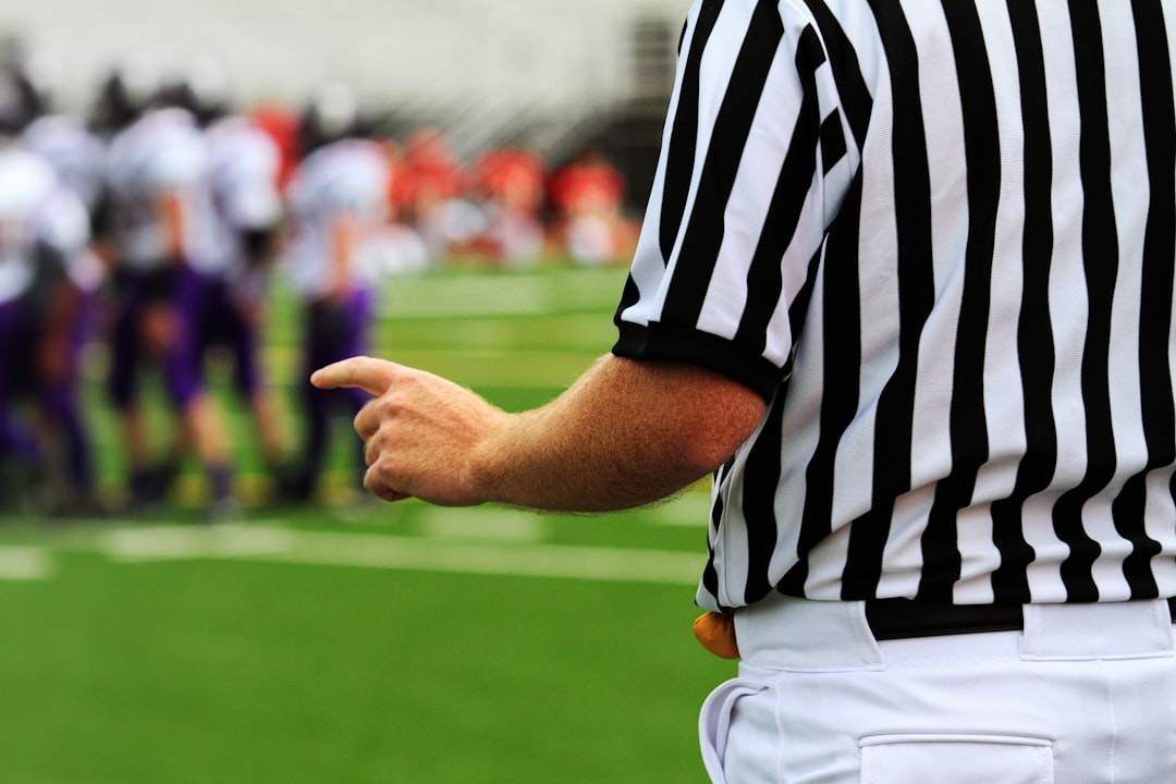 a man in a striped shirt football referee, official timeout, american football game