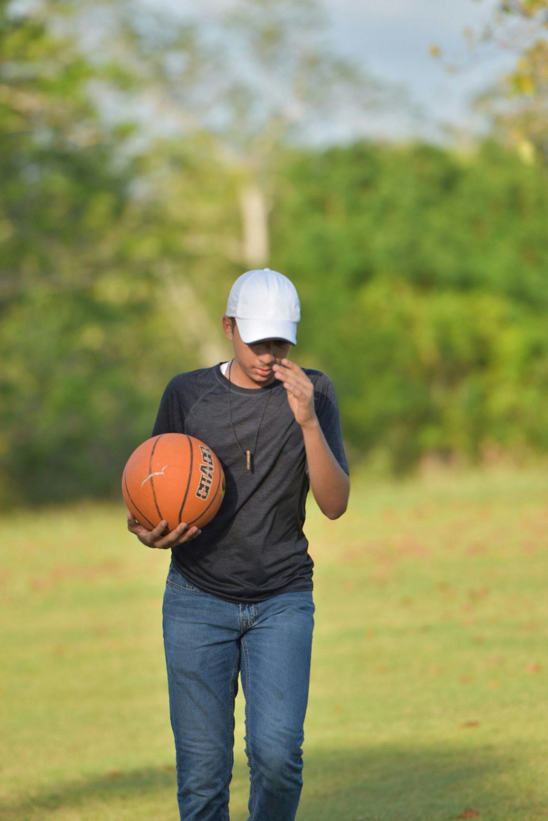 a man walking with a basketball in his hand baseball academy training, Dominican Republic teenagers, outdoor baseball field