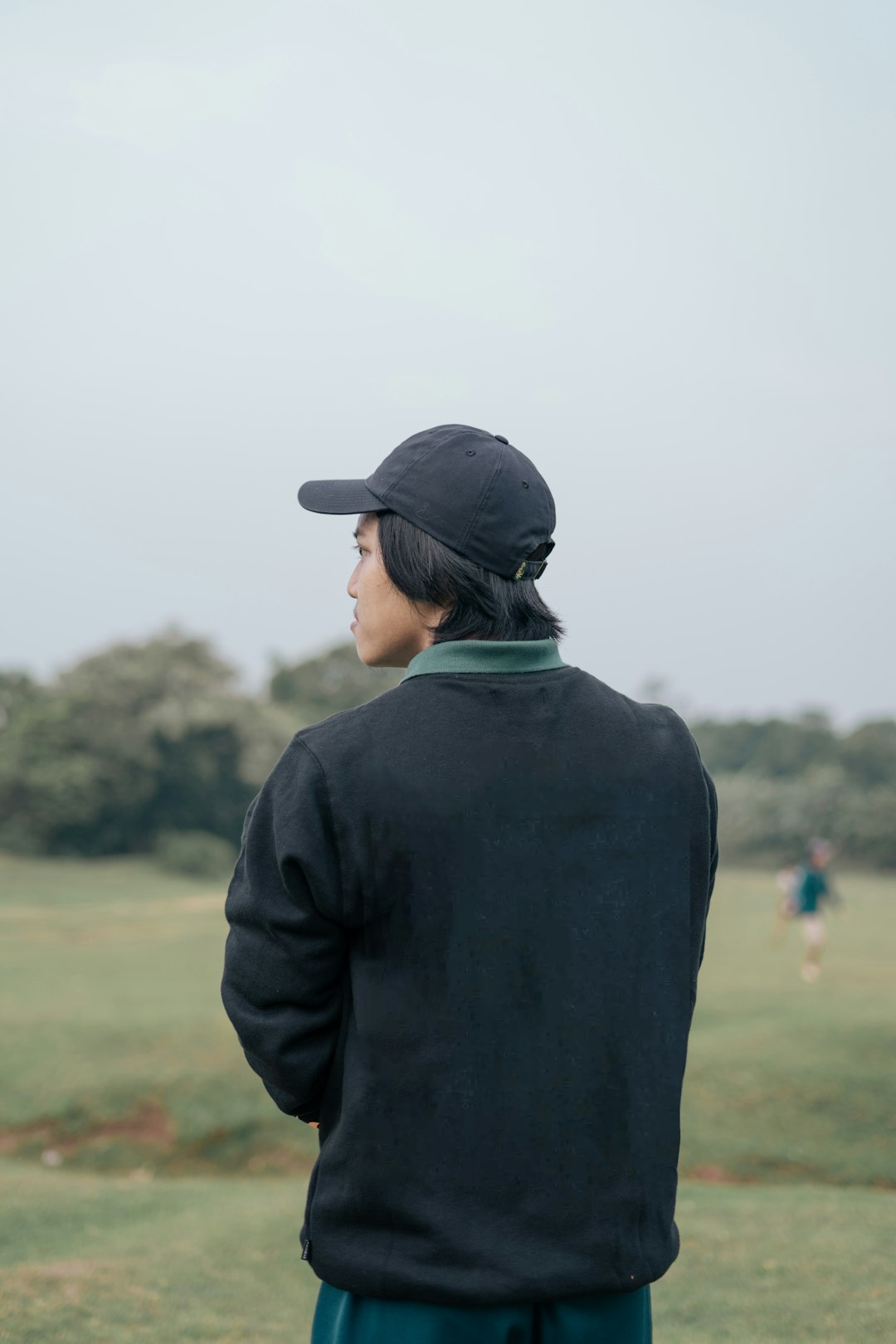 a person standing in a field with a baseball cap on tiger woods, golf trophy, green jacket