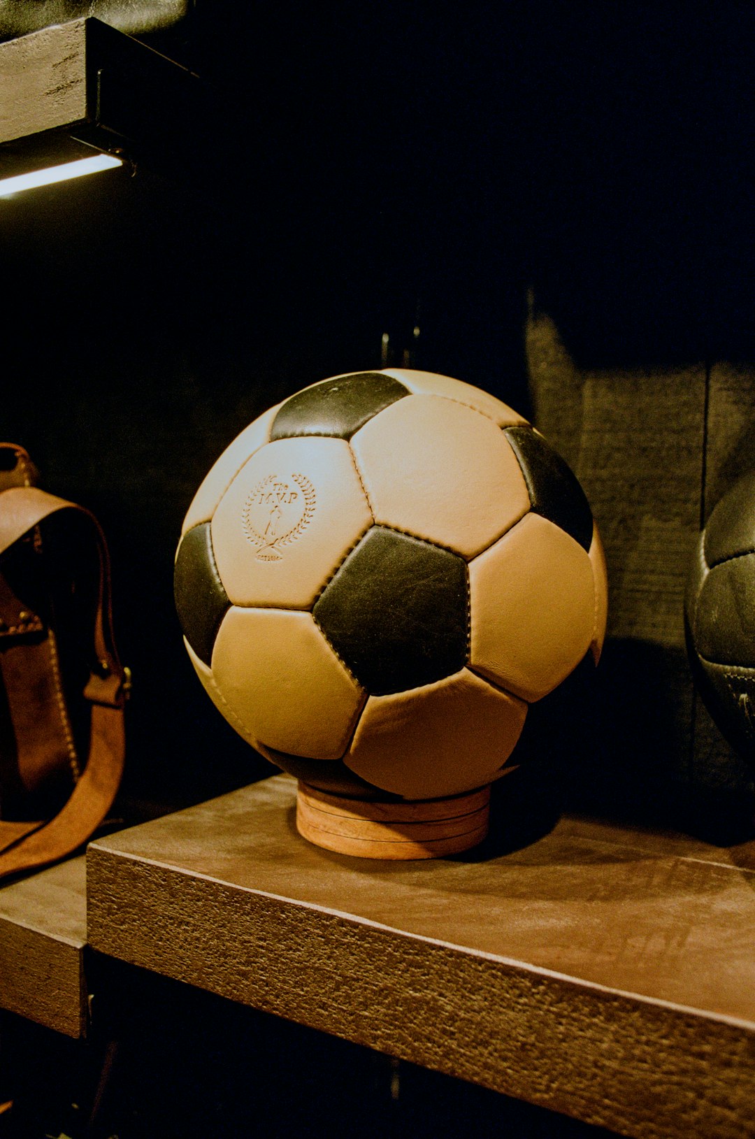 a soccer ball sitting on top of a wooden shelf historical,football,formation
