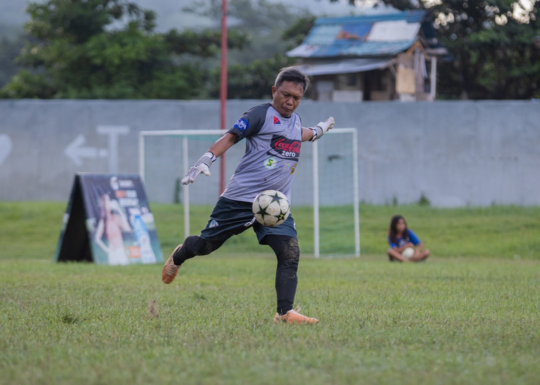 A young boy kicking a soccer ball on a field soccer player celebration