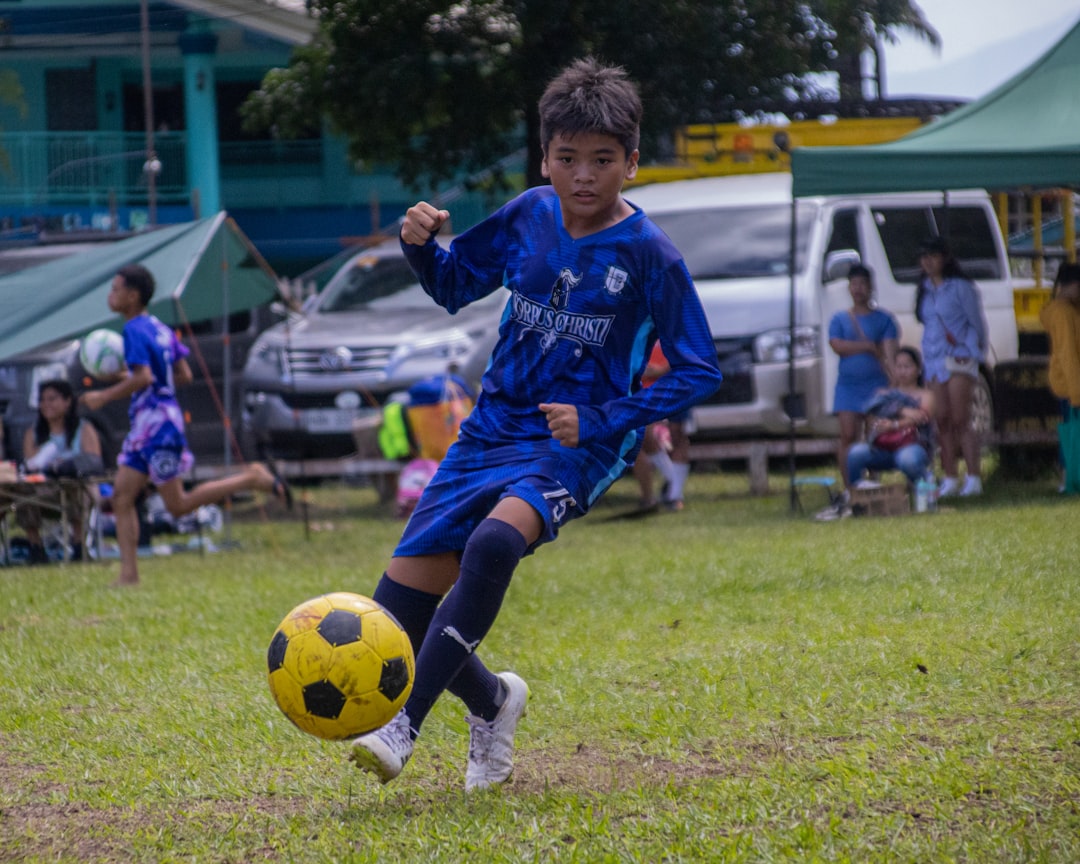a young boy kicking a soccer ball on a field soccer player celebration