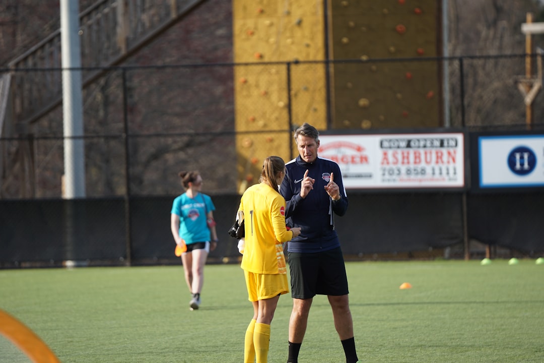 man and woman on green field soccer training coach player