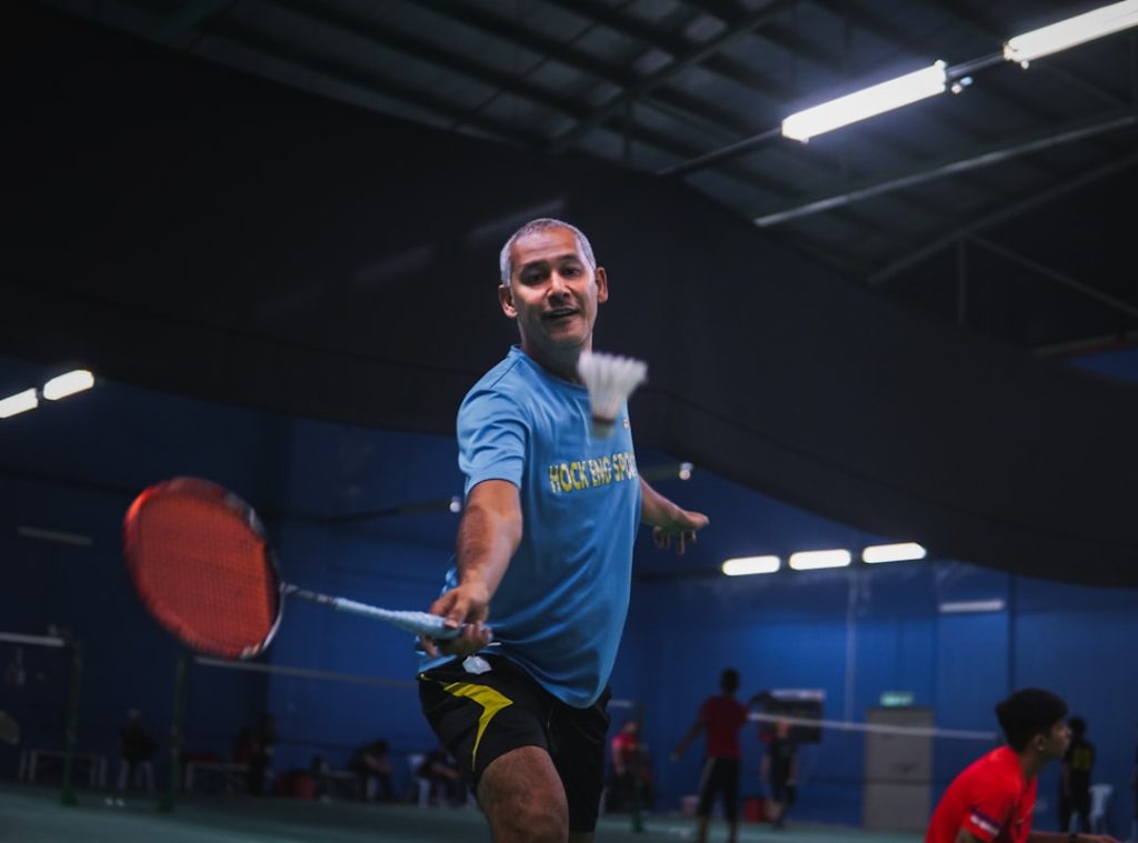 man in blue crew neck t shirt and black shorts holding red basketball football field lining,paint machine,sports lines