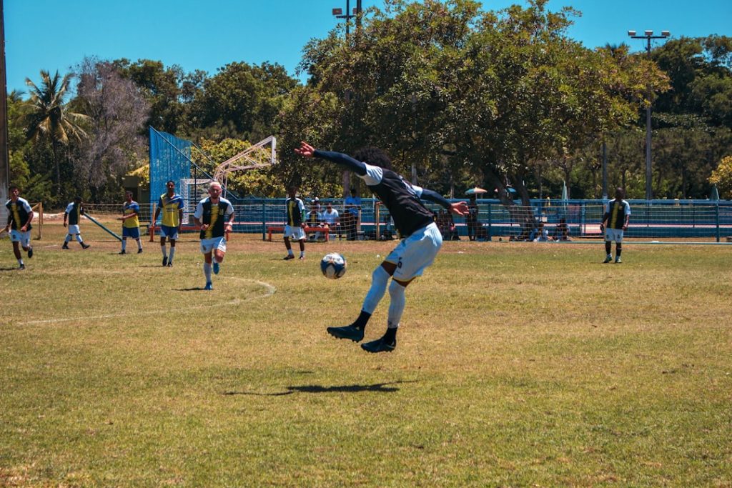 people playing soccer during daytime football catch, touchdown, players jumping
