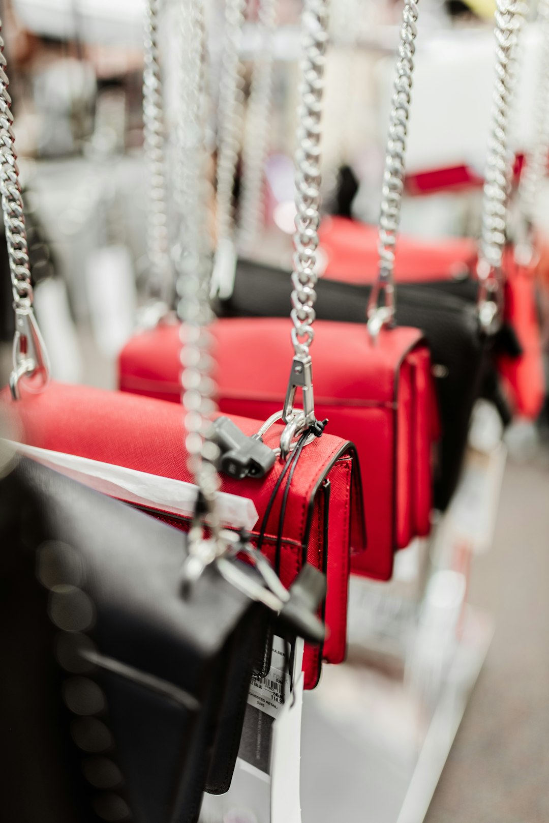 red and silver padlock on gray metal chain baseball gloves shopping, sports store, youth baseball equipment