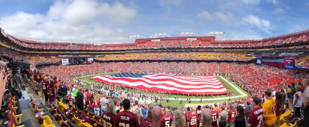USA flag american football stadium, players tackling, cheering fans