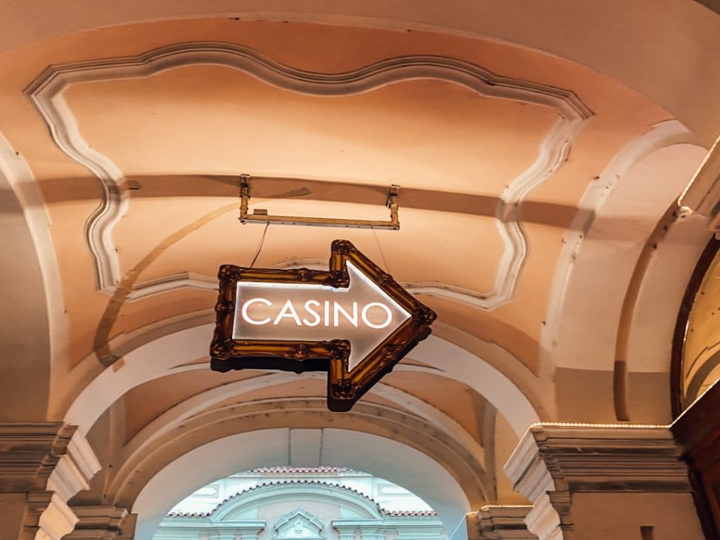 a casino sign hanging from the ceiling of a building casino software, gaming technology, online casino