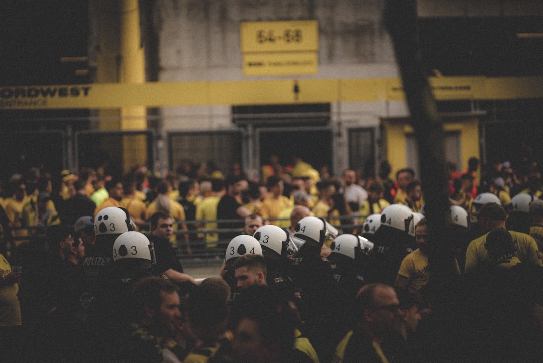 a large group of people wearing helmets in front of a building jude bellingham, borussia dortmund, football match