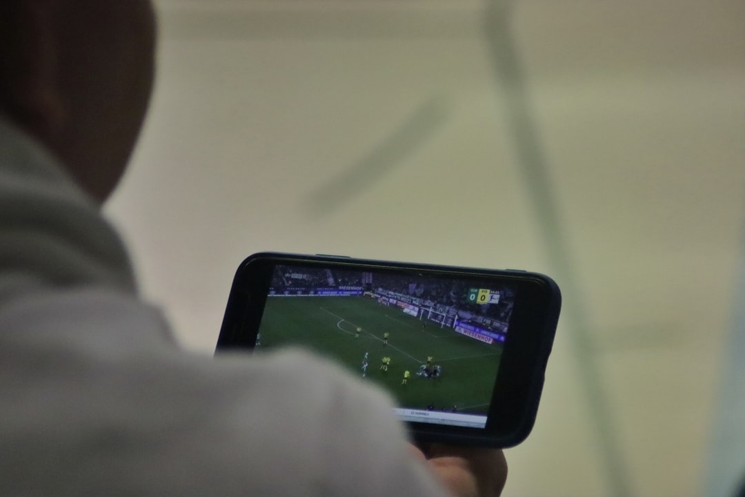 a man is playing a soccer game on his phone android app install,hesgoal apk setup,live football stream mobile