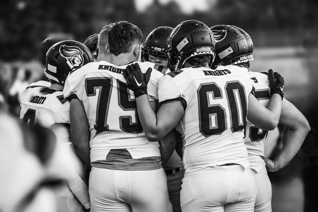 American football players huddle together before a game. college football team huddle strategy
