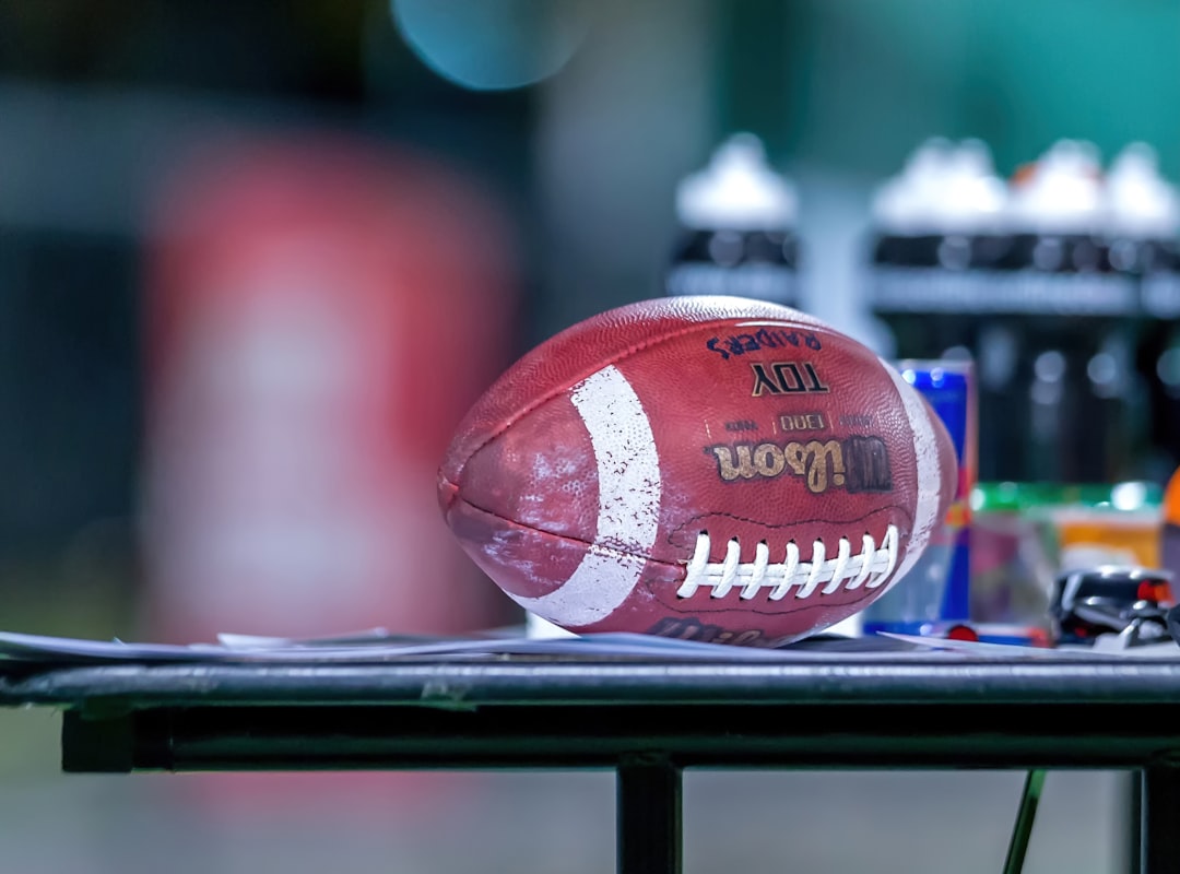 brown and blue football ball on black metal rack nfl draft stage, football event, sports fans