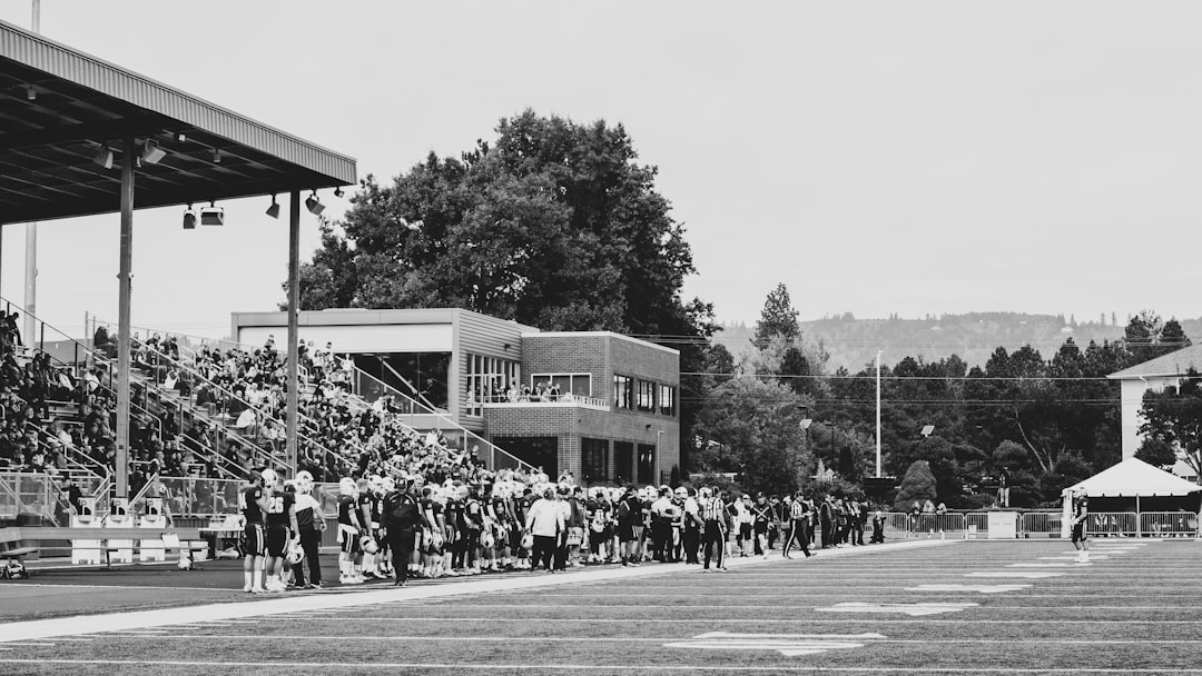 grayscale photography of people grinnell college fans cheering football game