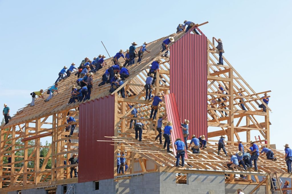 people building structure during daytime college football team huddle strategy