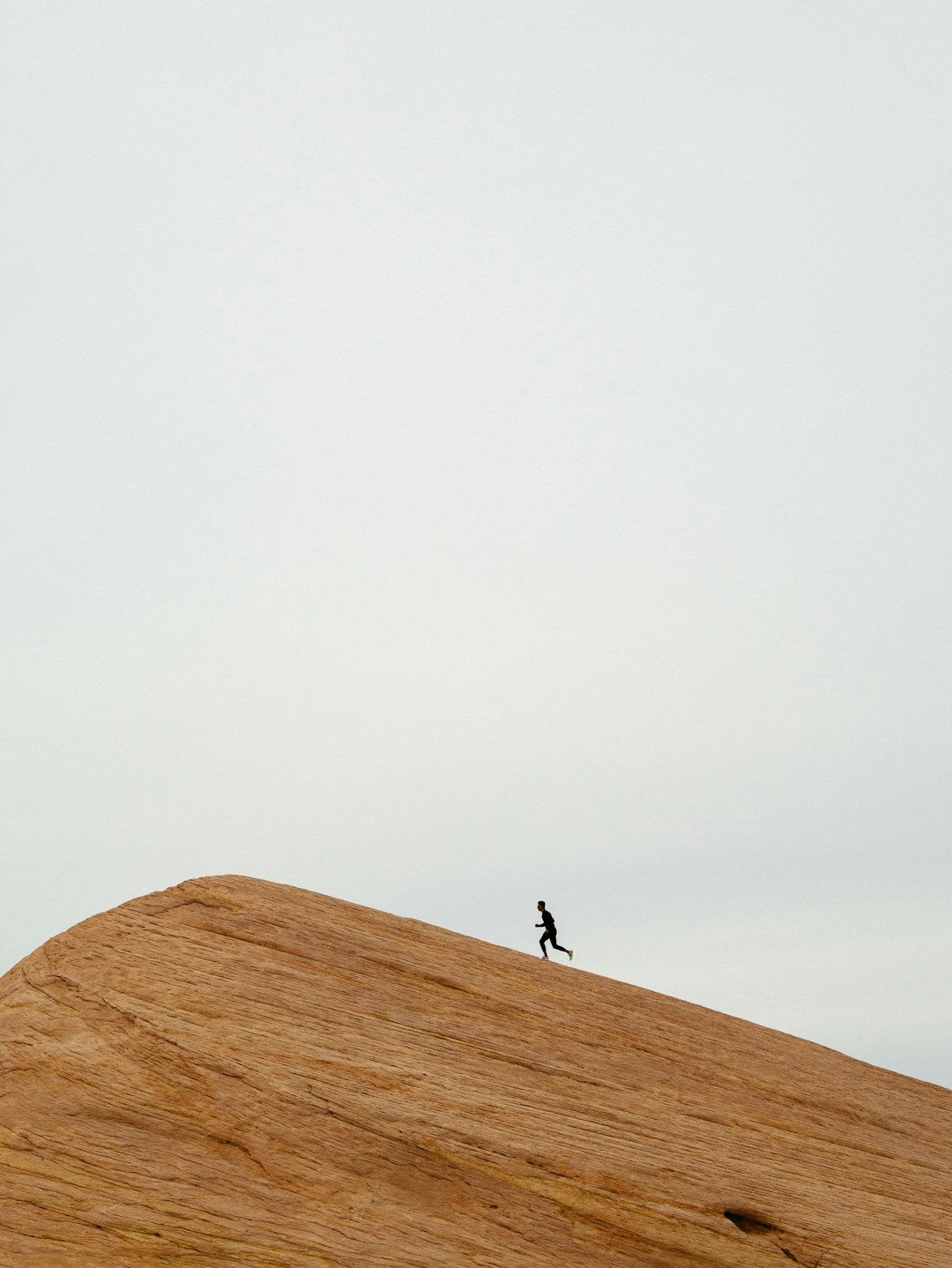 person running on top on hill during daytime football player, running, cleats, mud