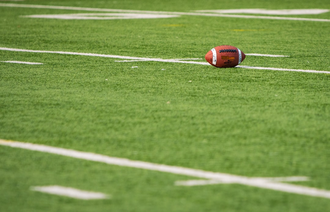 A football laying on a football field retro bowl gameplay, pixel football, NFL teams