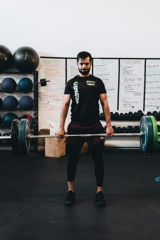 man in black crew neck t shirt and black shorts carrying barbell different sports, streaming, multiple devices