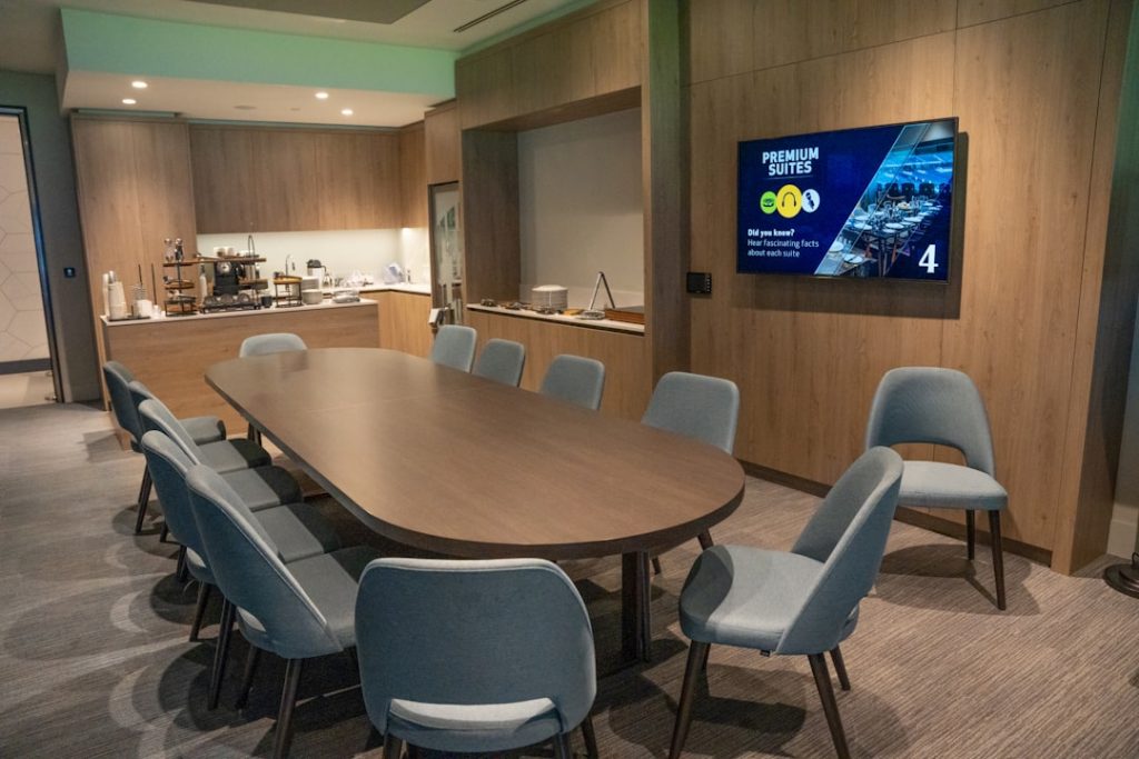a conference room with a large wooden table and blue chairs cowboys draft room, nfl 2025, team office