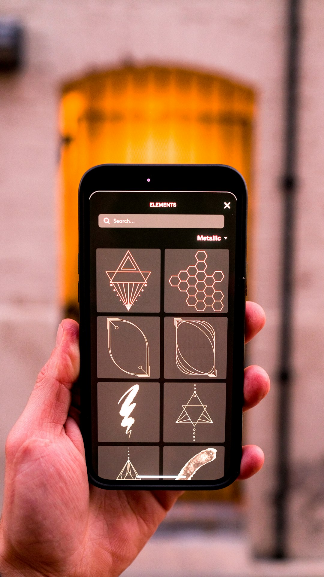 a hand holding a black and yellow electronic device mlb app, smartphone screen, restart symbol