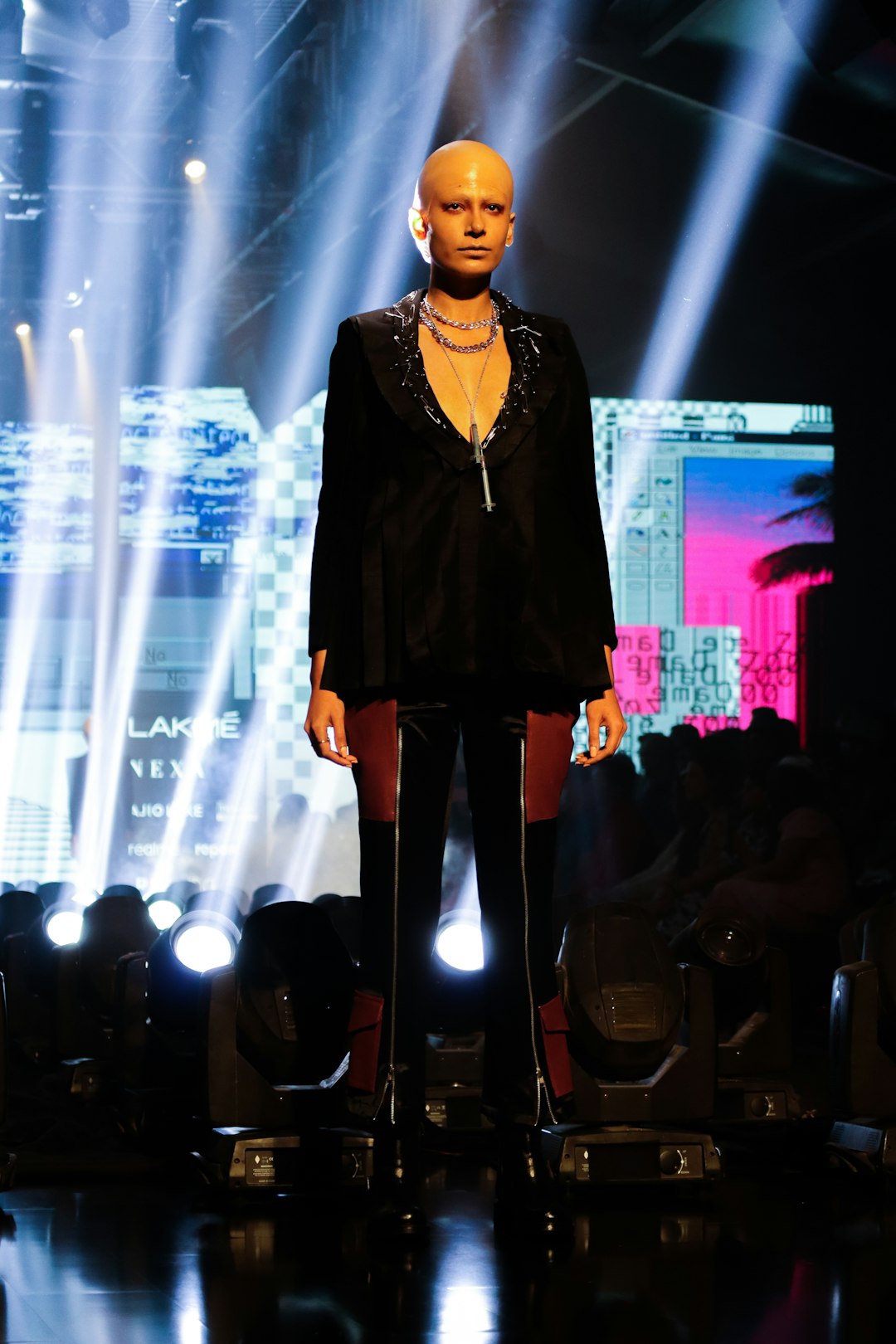 a mannequin wearing a black suit and gold necklace celebrities,f1 race,glamour,fashion show