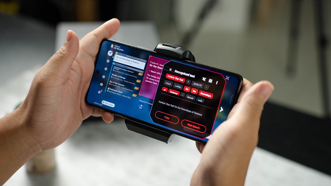 A person holding a cell phone in their hand nba 2k mobile app, mynba2k companion, game interface