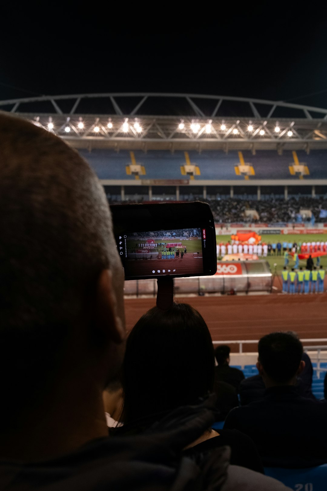 A crowd of people watching a horse race happy fans, watching sports, mobile phone