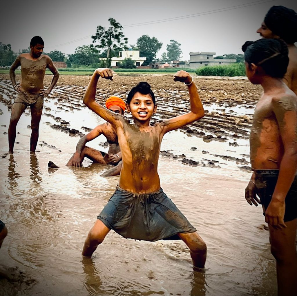 a group of men playing frisbee on the beach football rain players mud