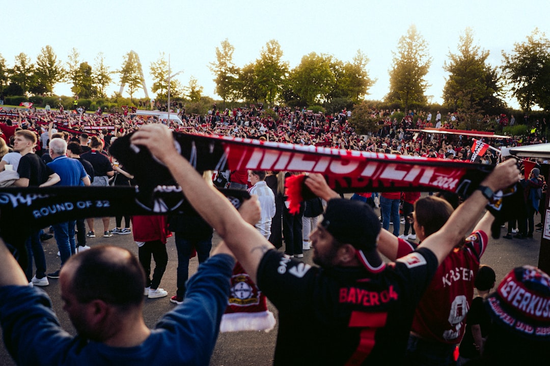 A group of people holding up signs in front of a crowd danish football fans, waving scarves, stadium atmosphere