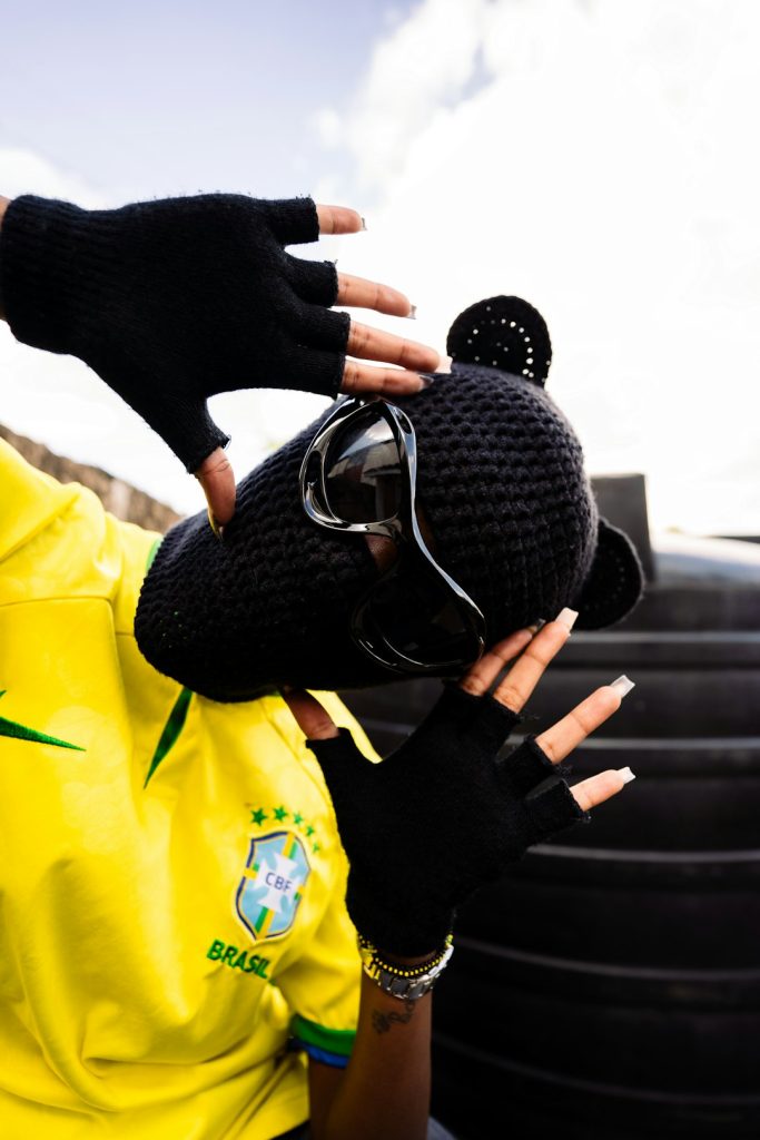 A woman wearing a yellow shirt and black gloves lineman gloves, protective gear, football tackle