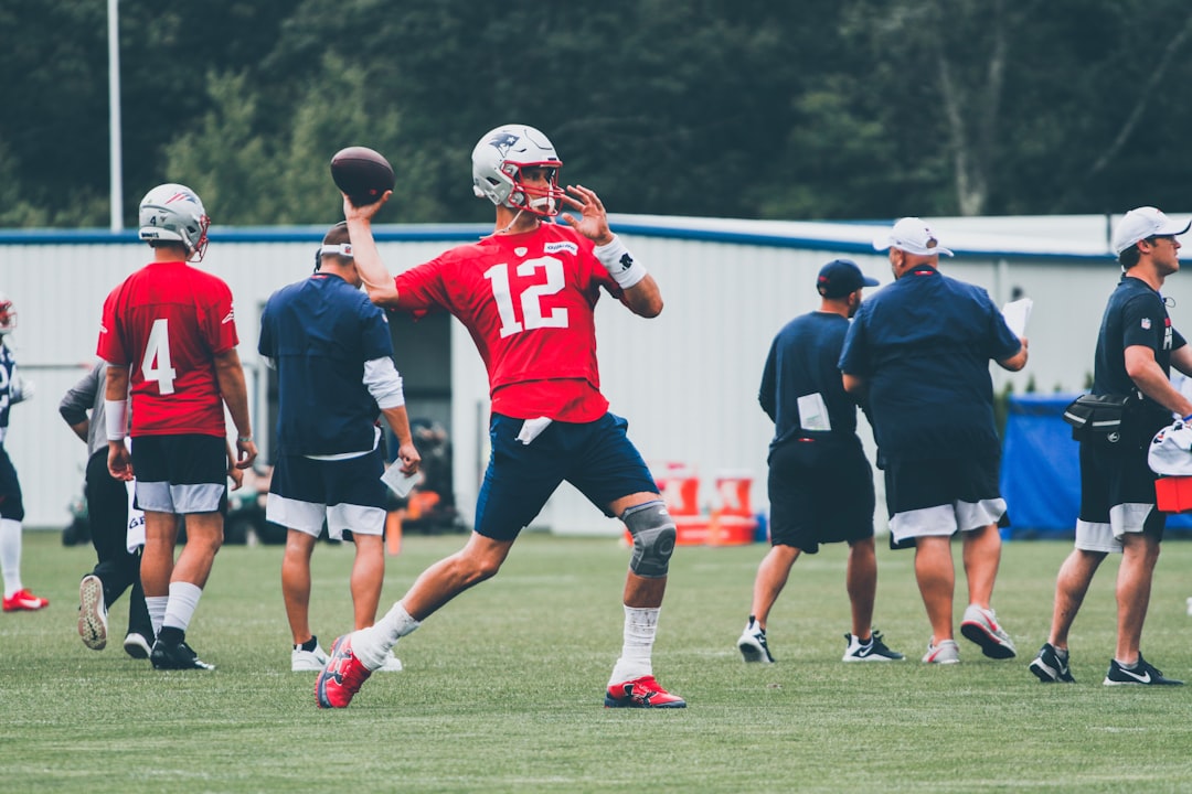 football players in red and white jersey shirt and black shorts nfl coach strategy, salary cap management, team planning