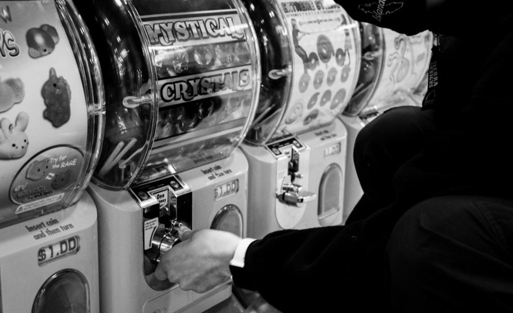 man in black long sleeve shirt holding stainless steel machine slot machines, gambling rewards, loyalty points