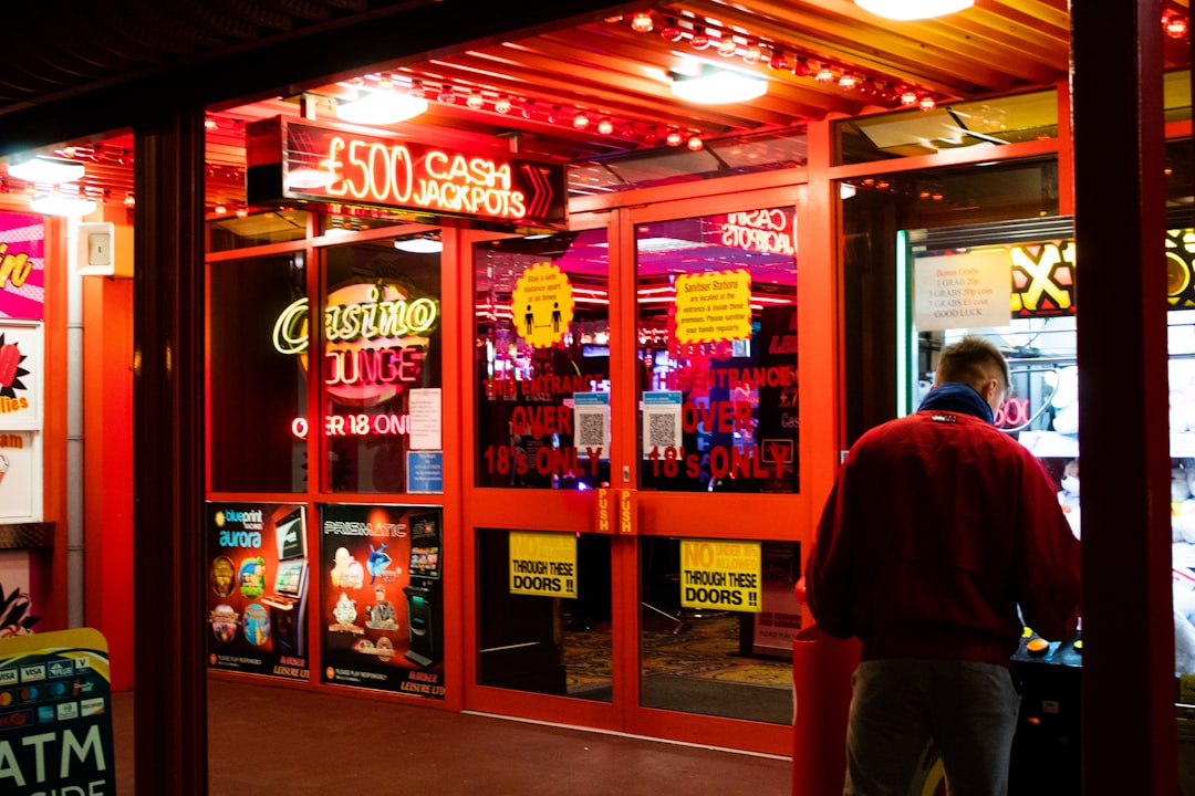 man in red shirt standing near store mobile betting, user interface, casino games