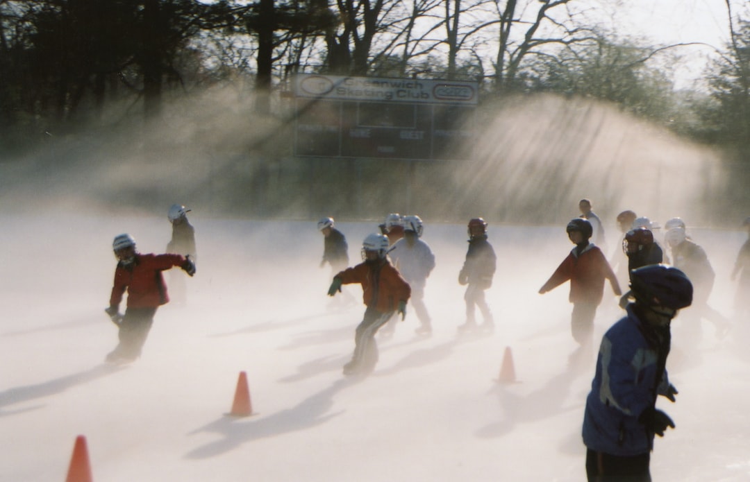 people walking on snow covered ground during daytime snow football players bundled cold