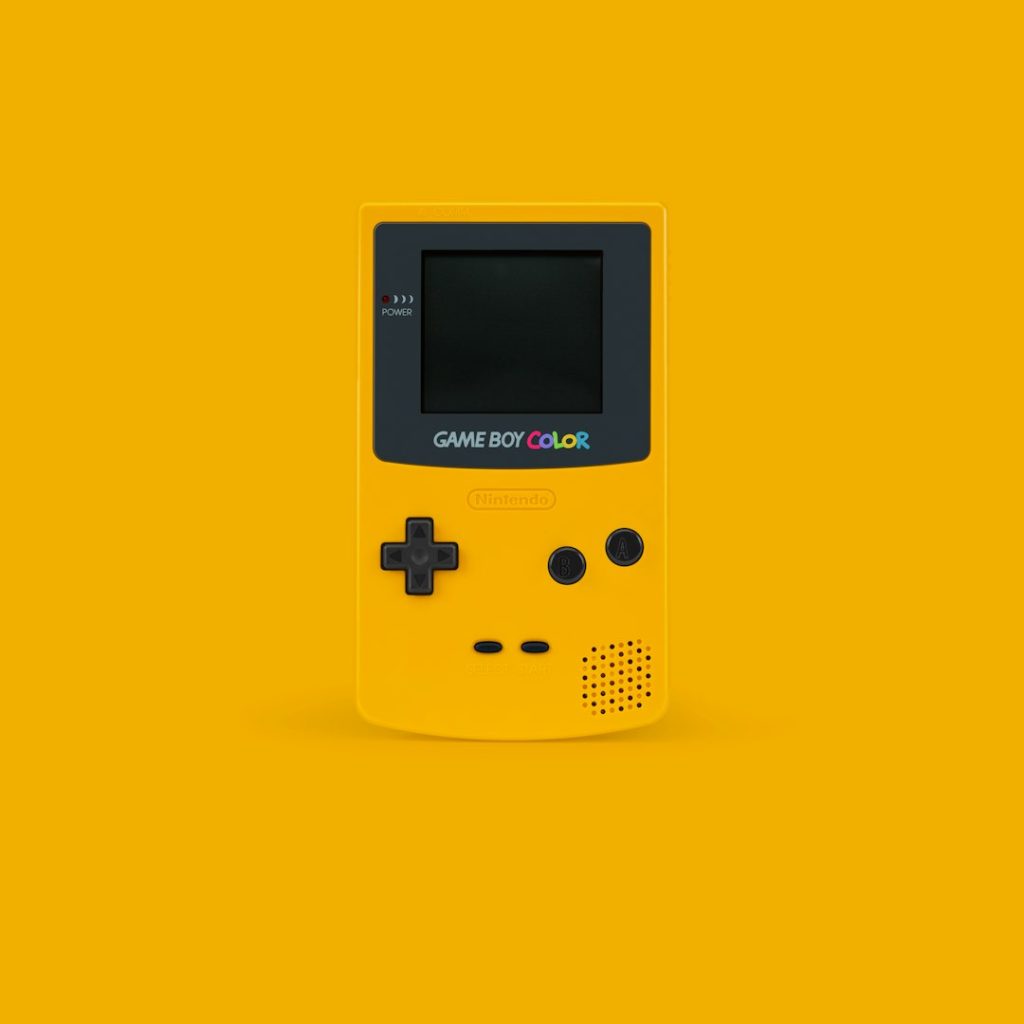 white and black Nintendo Game Boy Color on yellow surface retro football gameplay, pixel graphics, colorful helmet