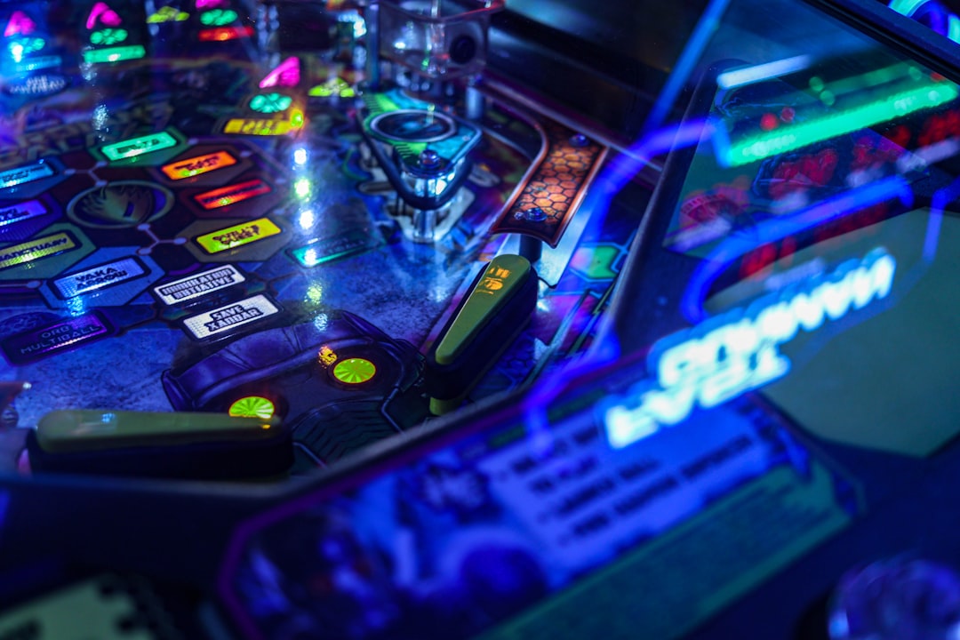 a close up of a pinball machine with neon lights teenager at computer, risky behavior, gambling warning