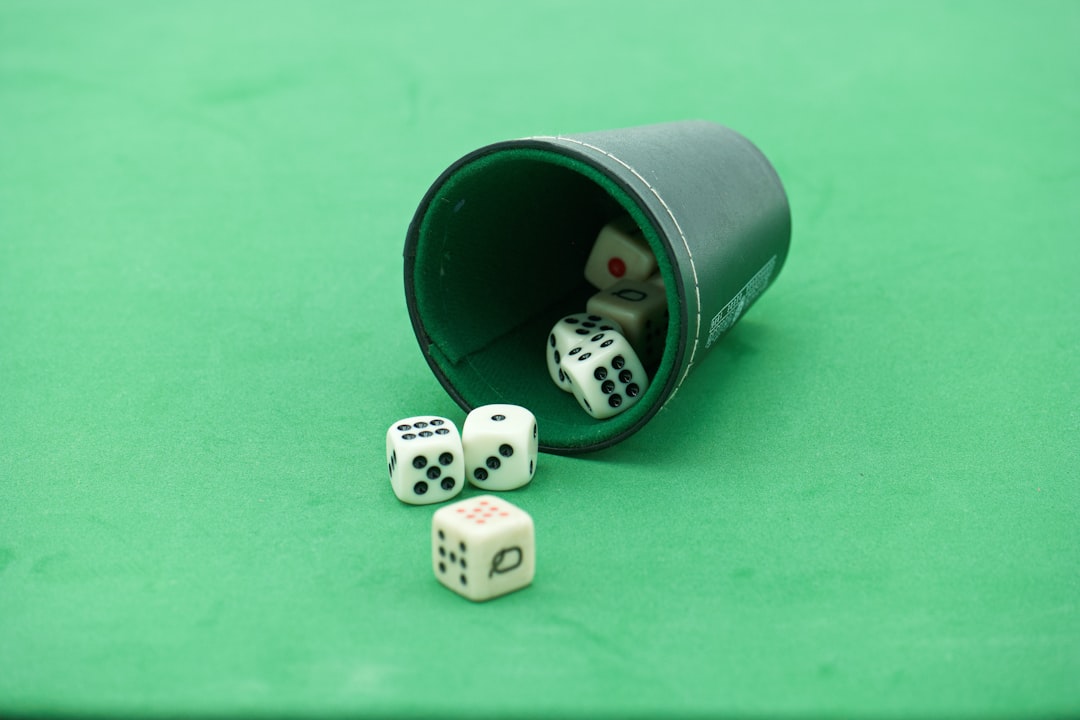 a green table topped with dice and a bucket usa map, sports betting laws, legalization