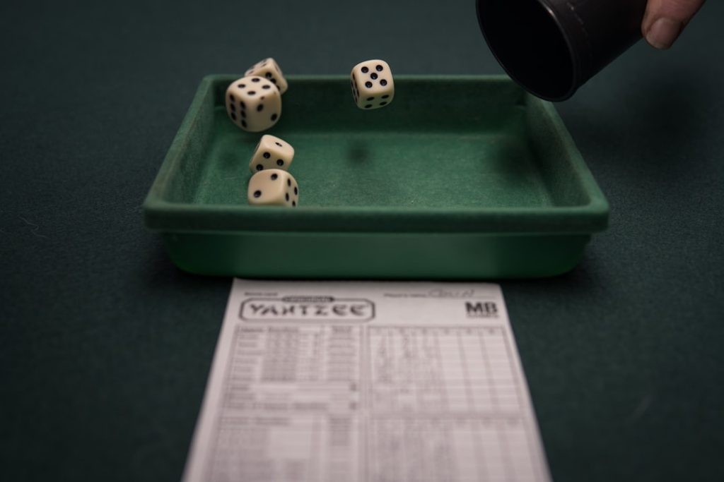 a green tray with dices on top of it usa map, sports betting laws, legalization
