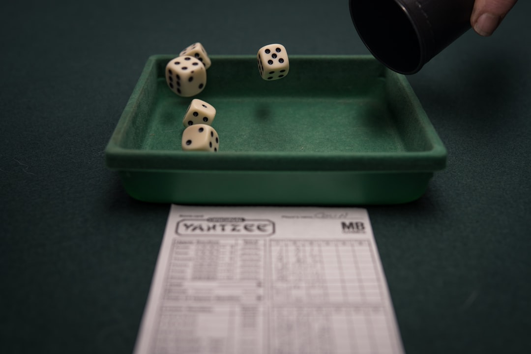 a green tray with dices on top of it usa map, sports betting laws, legalization