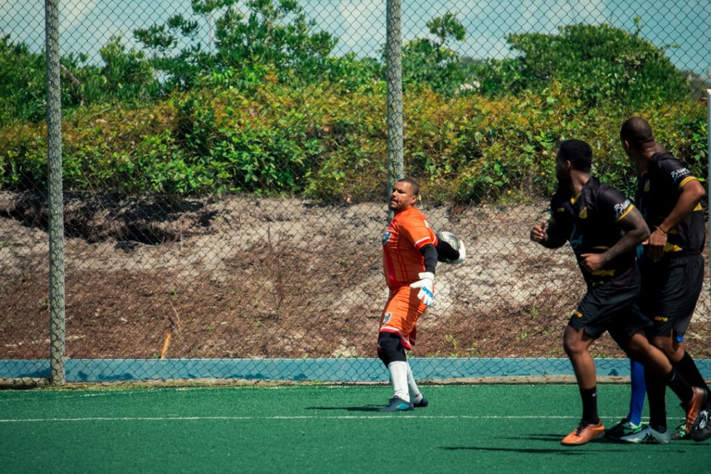 a group of men playing a game of soccer youth soccer player, training drill, rebounder net