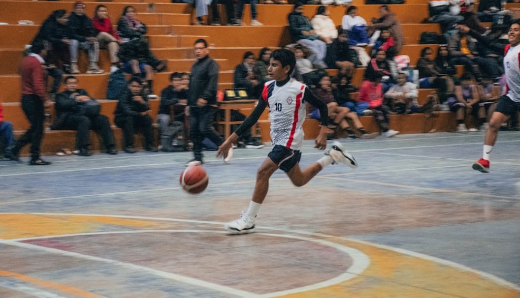 A group of young men playing a game of basketball football volley, player kicking ball mid air, football technique
