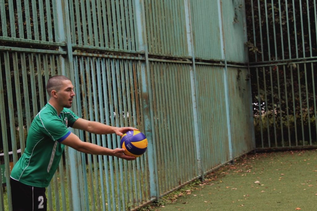 a man in a green shirt holding a soccer ball ronaldo free kick, trivela, soccer ball curve