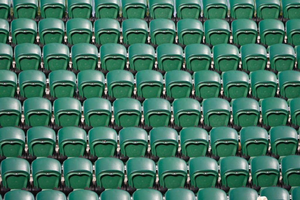a row of green seats in a stadium english football stadium, matchday fans, league table