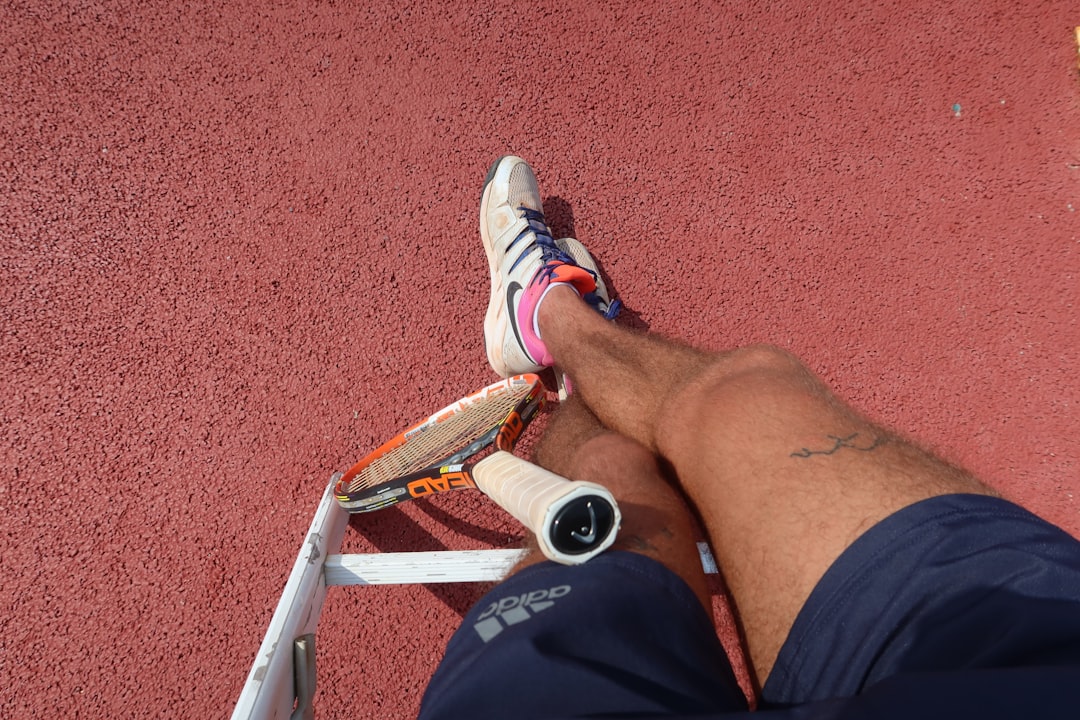 A tennis player rests on the court. athlete recovery, physiotherapy, return to sport