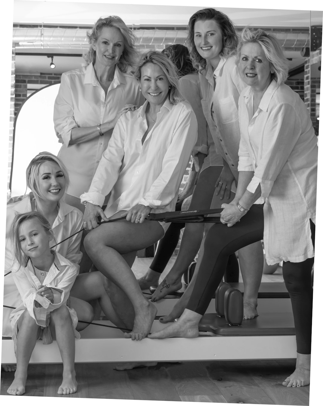 grayscale photo of 4 women sitting on the floor clinic staff, happy client, laser treatment