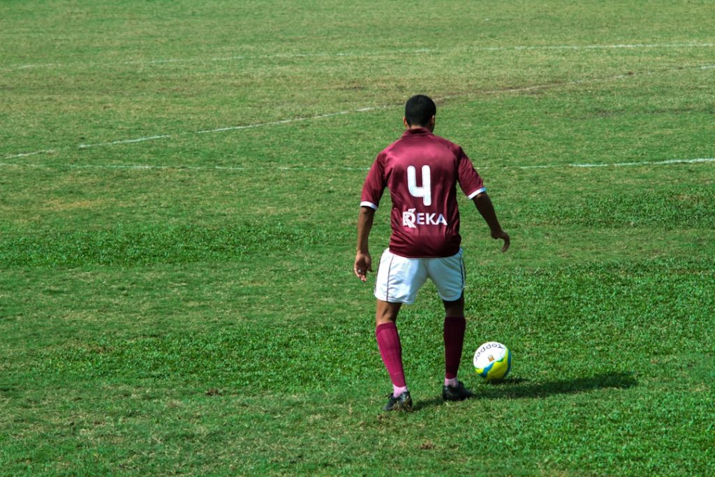 man in blue and white nike jersey shirt and white shorts playing soccer on green grass ronaldo free kick, trivela, soccer ball curve