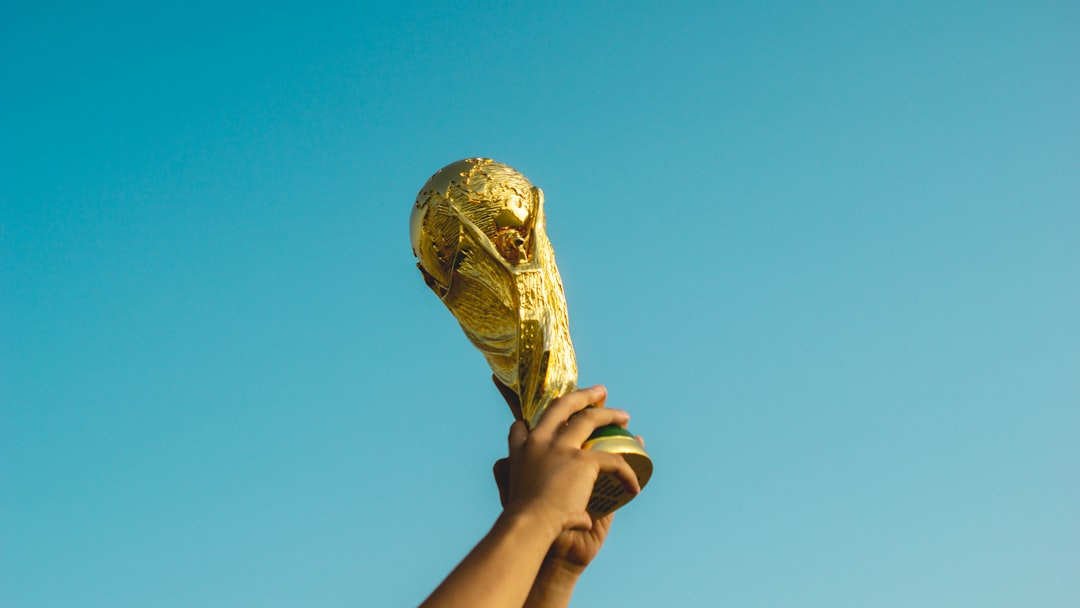 person holding gold trophy ronaldo messi trophies celebration